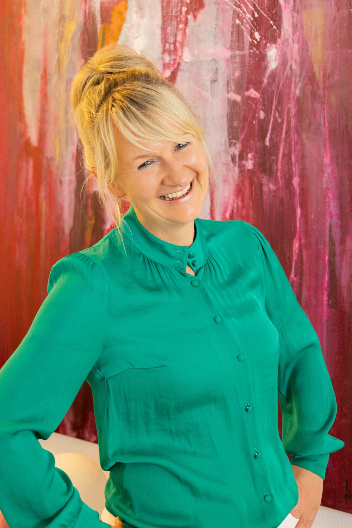 Nicole Riedl vor einem farbenfrohen Kunstwerk